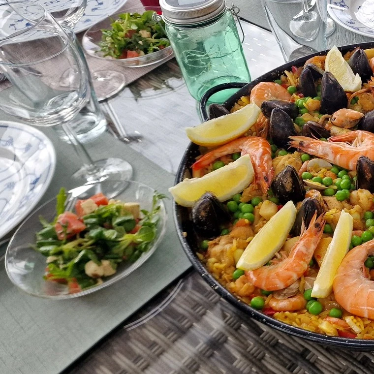 Gedeckter Tisch mit Paella und Sangria für genussvolle Mahlzeiten im Freien